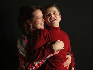 Judy Whitley shares a bonding moment with her son Dylan before music therapy in their home. Christina Ryan, Calgary Herald.