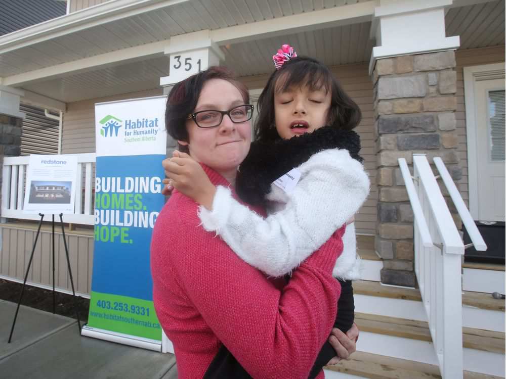 Suzanne Dumlao holds her daughter Autumn during a double dedication ceremony of habitat for Humanity homes for families with special needs children in the Redstone neighbourhood Wednesday November 9, 2016. Autumn suffers from a chromosome deficiency. Ted Rhodes Photo Postmedia Calgary